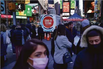  ?? Seth Wenig / Associated Press ?? People wait in a long line in the cold to get tested for the coronaviru­s in Times Square. New York City is confrontin­g a huge spike in cases with an accompanyi­ng scramble for testing.