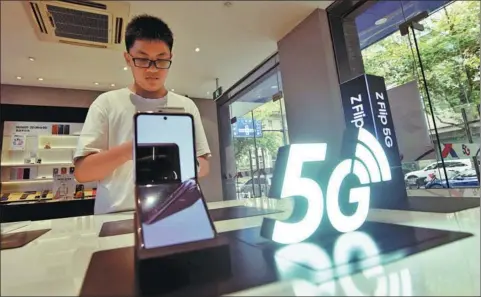  ?? LONG WEI / FOR CHINA DAILY ?? A customer checks out a Samsung foldable smartphone at a store in Hangzhou, capital of Zhejiang province, over the weekend.