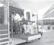  ?? Brett Coomer / Houston Chronicle ?? A MetroLift driver helps a passenger off a MetroLift bus upon arrival at the West Gray Multipurpo­se Center near Montrose.