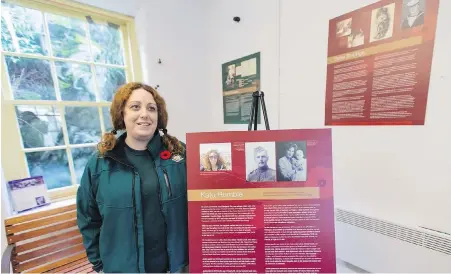  ??  ?? Kate Humble, curator of Fort Rodd Hill and Fisgard Lighthouse National Historic Site, with part of The 100 Years of Remembranc­e display.