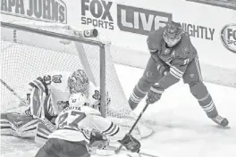  ?? PATRICK BREEN/AZCENTRAL SPORTS ?? The Coyotes' Martin Hanzal (11) tries to wrap a shot past Blackhawks' goaltender Antti Raanta on Saturday at Jobing.com Arena.