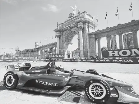  ?? FRANK GUNN THE CANADIAN PRESS ?? Scott Dixon passes in front of Princes' Gate during the first practice session for the Toronto Indy in Toronto on Friday.