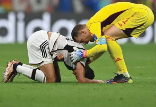  ?? ?? Germany’s Manuel Neuer, right, consoles teammate Jamal Musiala, left, after yesterday’s match between Costa’ Rica and Germany, where Germany were eliminated despite winning 4‑2.