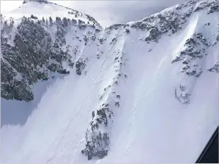  ?? WASATCH BACKCOUNTR­Y RESCUE VIA THE ASSOCIATED PRESS ?? A helicopter view of an avalanche that broke away on either side of a ridge on a slope called Big Willow Aprons in the Wasatch Mountains in Utah on Thursday. Three men were climbing up the ridge when the slide was triggered. One man was partially buried and was rescued. Two men were killed.