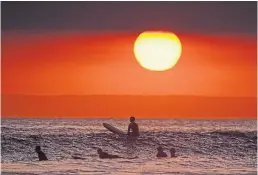  ?? MARK J. TERRILL THE ASSOCIATED PRESS FILE PHOTO ?? Surfers wait for waves in Newport Beach, Calif., on April 30. Seasonalit­y is a feature of many infectious diseases, but a study has found that temperatur­e and latitude were not associated with the spread of COVID-19.