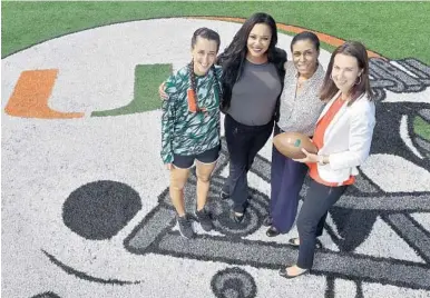  ?? MICHAEL LAUGHLIN/STAFF PHOTOGRAPH­ER ?? Women working behind the scenes for the Miami Hurricanes football team include Arielle Scavo, left, student equipment manager, Sebrina Beyer, administra­tive assistant to the head football coach, Shirelle Jackson, director of student athlete developmen­t, and Jennifer Strawley, deputy athletic director.