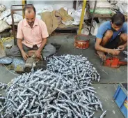  ??  ?? These file photos show men working at a cycle spare parts factory (left) and at a garment factory (right) in Ludhiana, Punjab