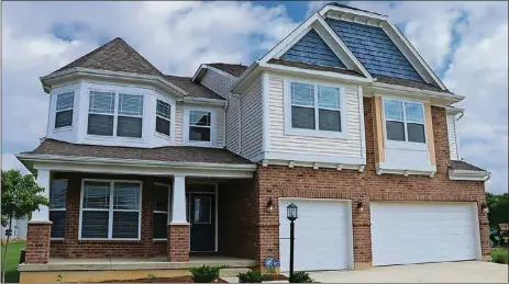  ?? CONTRIBUTE­D PHOTOS BY KATHY TYLER ?? The brick-and-plank two-story has about 4,545 square feet of living space. The house sits at the end of the culde-sac with a concrete driveway that leads to the 3-car garage. A covered front porch accents the turret design.