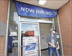  ?? aP-elaine Thompson ?? In this photo taken June 4 a customer walks out of a U.S. Post Office branch and under a banner advertisin­g a job opening, in Seattle. The U.S. unemployme­nt rate fell to 13.3% in May, and 2.5 million jobs were added — a surprising­ly positive reading in the midst of a recession that has paralyzed the economy and depressed the job market in the wake of the viral pandemic