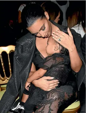  ?? GETTY IMAGES ?? Masters of minime dressing: Kim Kardashian with baby North West at the Givenchy show during Paris fashion week in 2015 wearing similar sheer black outfits.