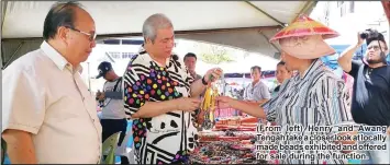  ??  ?? (From left) Henry and Awang Tengah take a closer look at locally made beads exhibited and offered for sale during the function.