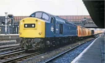  ?? JOHN E. HENDERSON/COLOUR RAIL ?? D260-266’s nose end doors were completely removed in 1965, the apertures were plated over and central headcode boxes installed. The boxes had square corners, unlike the rounded corners fitted to D345-D399 from new. During the mid-1970s, 40060/40061/40065 received the standard roundcorne­red boxes, whereas 40062-64/66 retained their square boxes. The reason for this seemingly inconseque­ntial aesthetic change is rather mysterious. 40063’s square-cornered headcode box is clear to see as it passes through Manchester Victoria with a refuse train on March 22 1982.