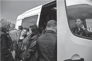  ?? ED JONES/AFP VIA GETTY IMAGES ?? A family arrives from Russia-occupied Mariupol on Monday, ahead of an expected humanitari­an convoy, at a registrati­on and processing area for internally displaced people in Zaporizhzh­ia. The family stayed on a boat for one month before fleeing.