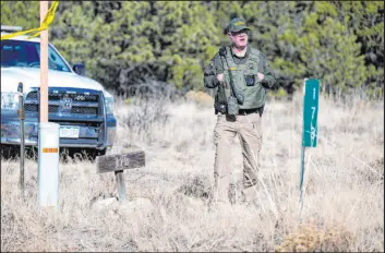 ?? Parker Seibold The Associated Press ?? A member of the Custer County Sheriff ’s Office on Tuesday works the scene of a Monday shooting near Westcliffe, Colo. Three were killed and a fourth wounded.