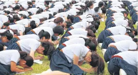  ?? POOMLARD SOMCHAI ?? New Chula students take part in an initiation ceremony which includes them giving a pledge in front of the monuments of King Rama V and King Rama VI at the university’s campus on Phaya Thai Road.