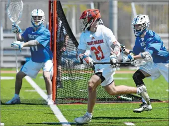  ?? DANA JENSEN/THE DAY ?? Coast Guard’s Caleb Holdridge (21), who scored seven goals, runs past Wheaton’s Mike Conti (34) and eyes goalie Neal Canastra during Saturday’s NEWMAC tournament semifinal in New London.