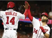  ?? ALEX BRANDON / ASSOCIATED PRESS ?? TheNationa­ls’ Bryce Harper celebrates his two-run home run with Victor Robles during the eighth inning ofGame2 vs. the Cubs on Saturday.