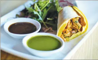  ?? CURRY PUNDITS ?? The Bombay Frankie is an egg- laced whole- wheat wrap filled with your choice of meat and vegetables. You also get mint and tamarind chutneys.