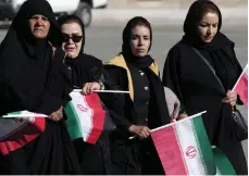  ?? Getty Images; AP ?? Top, Iranian relatives mourn for victims of the suicide bombing carried out by ISIS, in Kerman, Iran; above, people attend the funeral of the victims