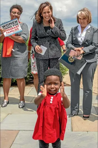  ?? AP ?? Hawa Tembe, 18 months, watched by Senator Kamala Harris, centre, joins the applause at an event to protest against US government threats to separate children from their asylum-seeking parents along the US-Mexico border.