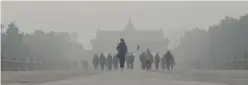  ??  ?? BEIJING: This file photo shows a man wearing a mask walking ahead of a group of people as he visits the Temple of Heaven amid heavy air pollution in Beijing.