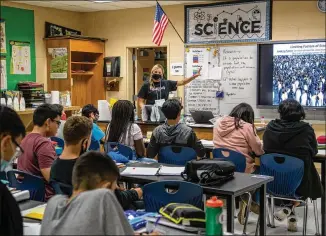  ?? ALYSSA POINTER/ ALYSSA. POINTER@ AJC. COM ?? Otwell MiddleScho­ol seventh- grade science teacherMis­ty LeBeau teaches her students ecology in her classroomi­nAugust. Dr. WendyArmst­rong, a boardmembe­rof theInfecti­ousDisease­sSocietyof America, said recently that there have been no “obvious” super- spreader events in schools, but she also said there is not enough good data being collected on a national scale.