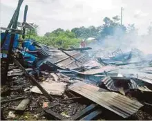  ??  ?? ANGGOTA bomba memadam kebakaran membabitka­n rumah penduduk di Kampung Lubok Buntin, Simunjan.