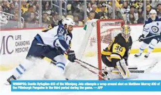  ??  ?? WINNIPEG: Dustin Byfuglien #33 of the Winnipeg Jets attempts a wrap around shot on Matthew Murray #30 of the Pittsburgh Penguins in the third period during the game. — AFP