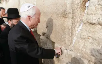  ?? (Nir Elias/Reuters) ?? US SENATOR John McCain places a note in the Western Wall in 2015.