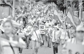 ??  ?? Supporters of Norman Quijano of the National Republican Alliance (ARENA) march towards the electoral authority headquarte­rs in San Salvador. — AFP photo
