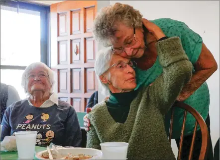  ?? MATT DAHLSEID/THE NEW MEXICAN ?? Arlene Decker, right, leans down to hug Annie Ortiz as Eleanor Riser looks on at the end of a lunch gathering of longtime neighbors Monday at Riser’s home on Camino Chueco. Riser is moving to assisted living after living in the same home since 1973.
