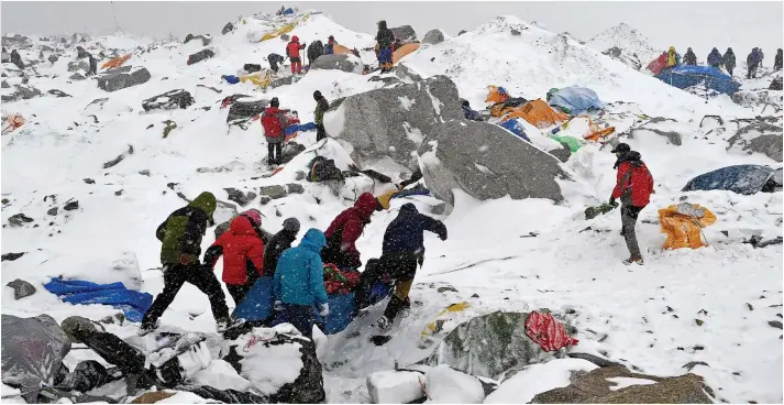  ??  ?? Frantic search: Rescue teams including Sherpas carry off an injured climber at Base Camp as others hunt for survivors among the damaged tents and equipment