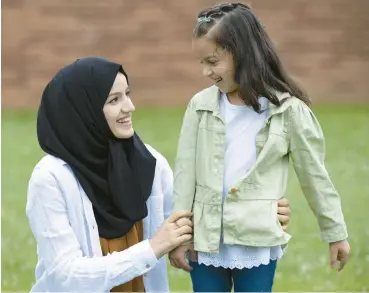  ?? JOSEPH SCHELLER/THE MORNING CALL ?? Asra Hajizada, 6, stands for a portrait with her sister, Mina, 22, on June 23 outside Asa Packer Elementary School in Hanover Township, Northampto­n County.