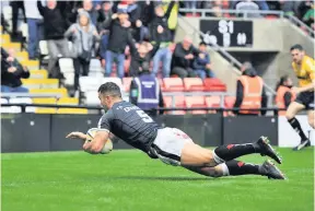  ??  ?? Jack Owens of Widnes Vikings dives over for the match winning try