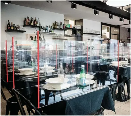  ?? Pictures: GETTY, REX ?? Restaurant­s in Italy, such as this one in Milan, above, are putting in precaution­s after being told they may be able to reopen in June. Commuters are also slowly returning to the city’s metro, left