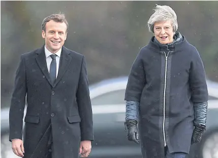  ?? BLOOMBERG ?? UK Prime Minister Theresa May and French President Emmanuel Macron arrive for a UK-France summit meeting at the military academy in Sandhurst, UK, on Thursday.