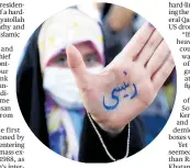  ??  ?? A supporter of presidenti­al candidate Ebrahim Raisi shows her hand with writing in Persian that reads “Raisi”, during a rally in Tehran.