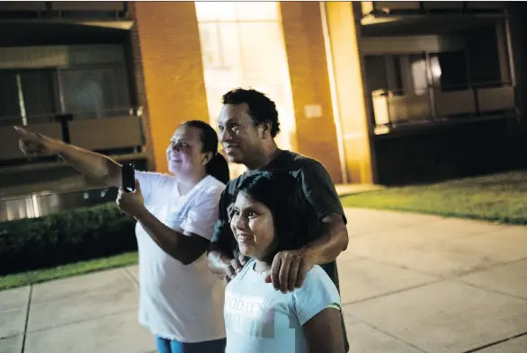  ?? SARAH L. VOISIN/WASHINGTON POST. ?? José Piña, Madai Ledezma, and their daughter Heather watch fireworks outside their apartment. It was Heather’s ninth birthday.