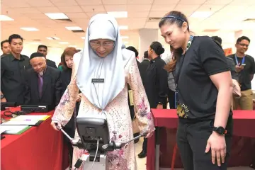  ??  ?? Wan Azizah tries her hand at a ‘Bioelectri­cal Impedance Analysis’ machine during the launching of World Heart Day at Universiti Malaya Medical Centre in Kuala Lumpur. — Bernama photo