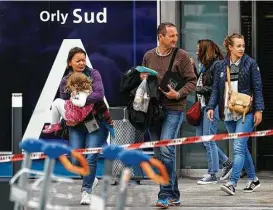  ?? Kamil Zihnioglu / Associated Press ?? Travelers evacuate Orly Airport, south of Paris, after an attack Saturday in which a man was killed after holding a pistol to a patrolling soldier’s head.