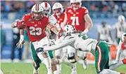  ?? [AP PHOTO] ?? Wisconsin running back Jonathan Taylor (23) breaks a tackle attempt by Miami defensive back Sheldrick Redwine (22) during the first half of the Pinstripe Bowl, on Thursday in New York. Wisconsin won 35-3.