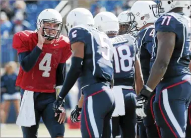  ?? JESSICA HILL — THE ASSOCIATED PRESS FILE PHOTO ?? UConn quarterbac­k Bryant Shirreffs, left, talks with his team during the first half of UConn’s Blue-White spring game at Rentschler Field in April.