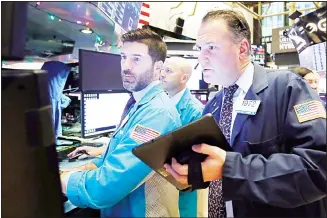  ?? In this file photo specialist Thomas McArdle (left), and trader Jonathan Corpina (right), work on the floor of the New
York Stock Exchange. (AP) ??