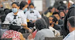  ?? FRANK AUGSTEIN/AP ?? Restaurant staff members wear face masks Sept. 22 in Soho in London.