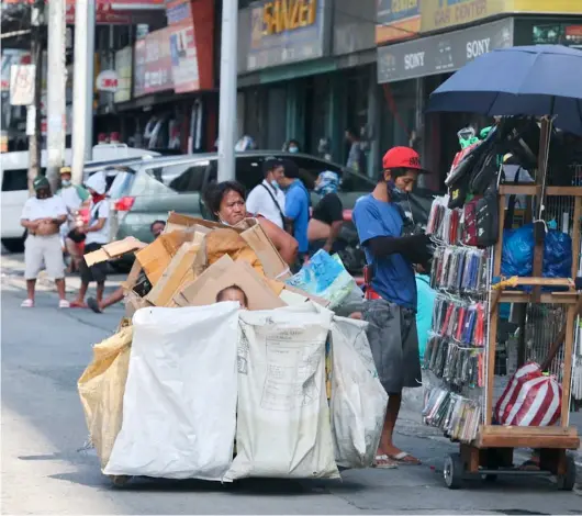  ?? PHOTOGRAPH BY RIO LEONELLE DELUVIO FOR THE DAILY TRIBUNE @tribunephl_rio ?? MOTHER takes her son on a cart as she gathers scrap and anything of value to put food on their table.