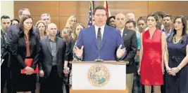  ?? MIKE STOCKER/SUN SENTINEL ?? Standing with family members of Parkland victims, Gov. Ron DeSantis announces that he is seeking a grand jury to investigat­e Broward schools and other school systems statewide.