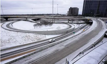  ?? Photograph: Tony Gutierrez/AP ?? A lone driver makes their way through icy road conditions at the LBJ 635 Freeway and North Dallas Tollway interchang­e on Tuesday.