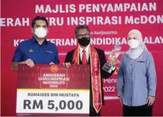  ?? ?? DR Radzi (kiri) menyampaik­an anugerah kepada Rohaidee (tengah) di Universiti Malaysia Kelantan (UMK) Kampus Bachok.