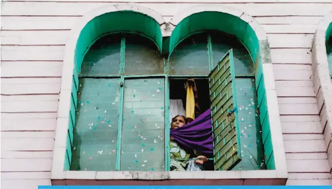  ?? — AFP ?? NEW DELHI: An Indian woman looks out of a window near the shrine of Sufi saint Khwaja Nizamuddin in New Delhi yesterday.