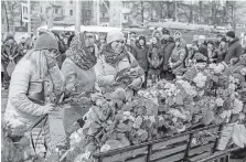  ?? THE ASSOCIATED PRESS ?? Last Monday, people lay flowers for the victims of a fire in a multi-story shopping center in the Siberian city of Kemerovo, about 1,900 miles east of Moscow, Russia.